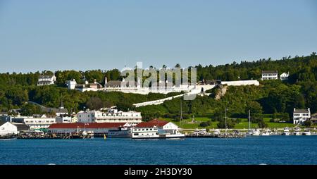 Blick vom Wasser auf die Passagierfähre auf das historische Fort Mackinac und die Uferpromenade und den Hafen, Mackinac Island, Michigan, USA Stockfoto