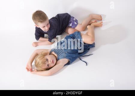 Bruder und Schwester liegen schlaff nebeneinander auf dem Boden Stockfoto