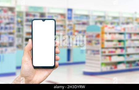 Pharmazie-Hintergrund. Blur Zähler der Apotheke mit Medikamenten, Tabletten, Pillen und Hand mit Smartphone. Hochwertige Fotos Stockfoto