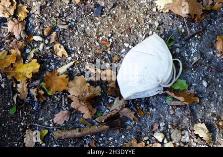 KN95- oder N95 FFP2-Maske zum Schutz von PM 2.5 und Coronavirus (COVID-19). Anti-Verschmutzung Maske.Luft Gesichtsmaske, FFP2 N95 Maske auf dem herbstlichen Bürgersteig. Stockfoto