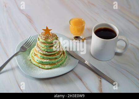 Weihnachtsbaum geformte Pfannkuchen auf dem Tisch. Konzept für ein weihnachtliches Frühstück Stockfoto