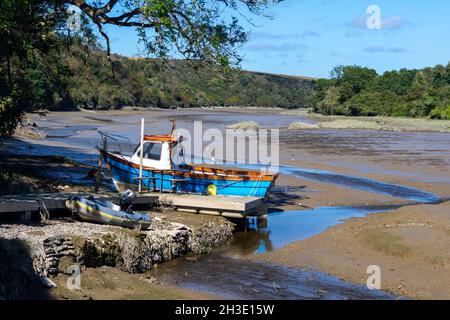 Ein kleines Fischerboot liegt auf dem Fluss Camel, während die Ebbe ausläuft. Der Fluss endet seine Reise in Padstow, Cornwall, nachdem er auf Bodmin Moor gestartet ist Stockfoto