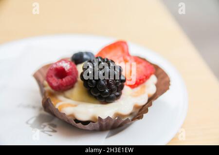 Obsttartlet mit Erdbeeren, Brombeeren und Himbeeren, serviert auf einem Teller Stockfoto