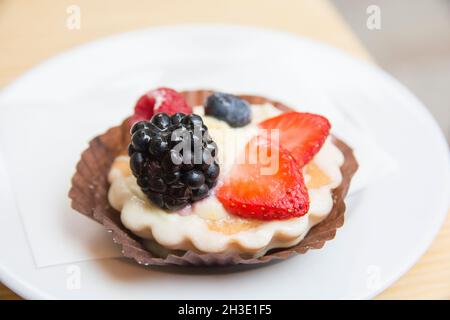 Obsttartlet mit Erdbeeren, Brombeeren und Himbeeren, serviert auf einem Teller Stockfoto