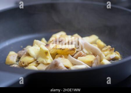Sautierte Scheiben von frischen Pilzen, die in der Pfanne gekocht werden. Nahaufnahme. Stockfoto