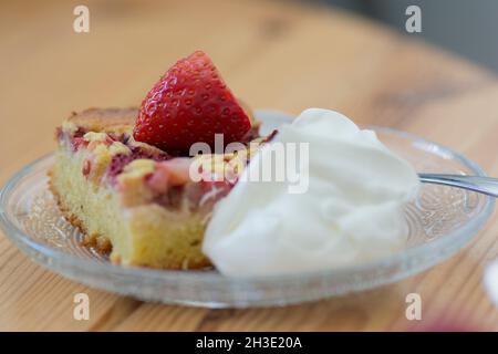 Eine Scheibe Erdbeerkuchen mit Creme, serviert auf einer Platte Stockfoto