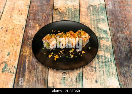 Norwegisches Lachs-Uramaki-Sushi flambiert mit reifer Avocado, knackigen Zwiebeln und Nori-Algen Stockfoto