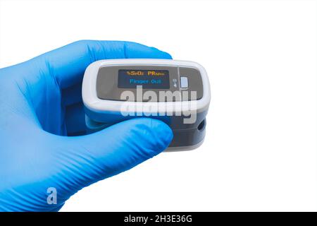 Arzt Hand in schützende medizinische Handschuhe halten moderne Fingerspitze Pulsoximeter auf einem weißen Hintergrund, isoliert. Stockfoto