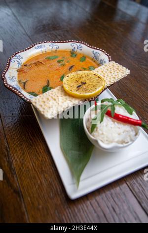tom Yam Suppe mit Reis auf einem weißen Teller Stockfoto