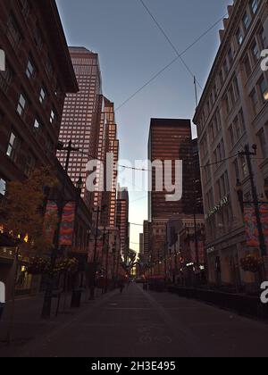 Schöner Blick auf die berühmte Einkaufsstraße 8th Avenue SW in der Innenstadt von Calgary im Abendlicht mit Wolkenkratzern. Stockfoto