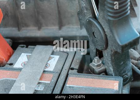 Anlasserklemmen, die an den Klemmen einer staubigen alten Autobatterie befestigt sind Stockfoto