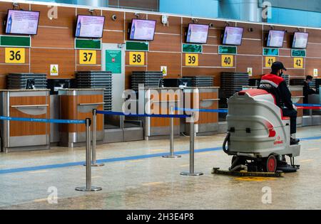 11. Mai 2021, Moskau, Russland. Ein Mitarbeiter mit Keilabsatz auf einer Scheuersaugmaschine im Passagierterminal des Flughafens Sheremetyevo. Stockfoto