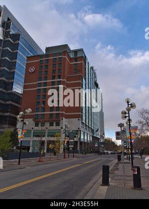 Blick auf das Hotel das Sheraton Suites Calgary Eau Claire, das von Marriott International Inc. Betrieben wird, befindet sich in der Innenstadt mit einer leeren Straße im Abendlicht im Herbst. Stockfoto