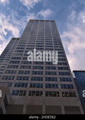 Blick in den niedrigen Winkel des Wolkenkratzers Shell Center (140 m) in der Innenstadt von Calgary mit Logo auf der Oberseite im Abendlicht mit teilweise bewölktem Himmel. Stockfoto