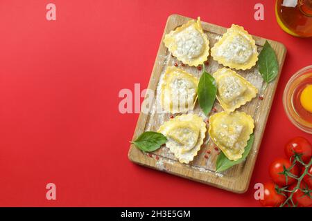 Konzept des Kochens von Ravioli auf rotem Hintergrund Stockfoto