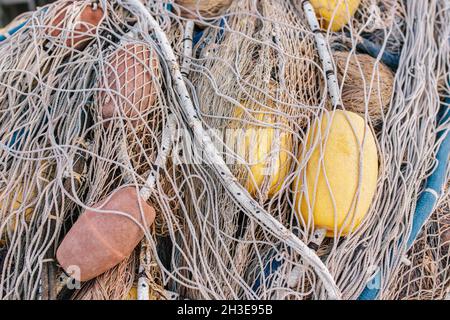Unordentliches Fischernetz mit bunten Schwimmern auf Seilen auf dem Boot an sonnigen Tag Stockfoto