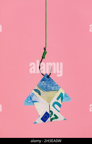 Haken auf Linie ziehen Origami-Fisch geformt Euro-Banknote als Konzept des Reichtums und Geld verdienen vor rosa Hintergrund Stockfoto