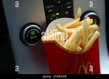 Ein McDonald's-Menü im Auto. Hier pommes Frites am Schalthebel. Stockfoto