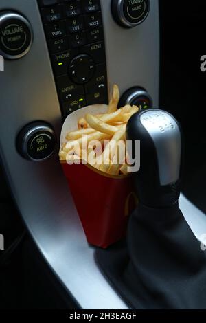 Ein McDonald's-Menü im Auto. Hier pommes Frites am Schalthebel. Stockfoto