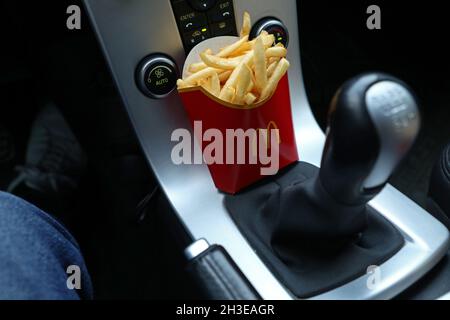Ein McDonald's-Menü im Auto. Hier pommes Frites am Schalthebel. Stockfoto