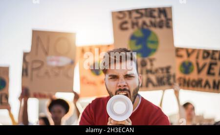 Junge Gruppe von Demonstranten, die aus verschiedenen Kulturen und Rennen unterwegs sind, kämpfen für Plastikverschmutzung und Klimawandel - Fokus auf Mann mit Megaphon Stockfoto