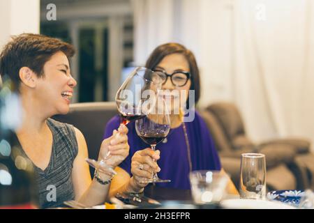 Glückliche Familie Tochter Toasting Gläser Rotwein mit Mutter zu Hause. Stockfoto