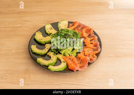 Japanischer Wakame-Algensalat mit mexikanischer Avocado und geräuchertem norwegischen Lachs Stockfoto