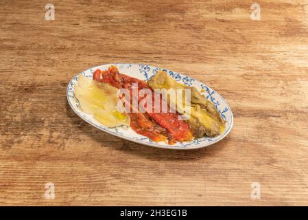 Teller mit typischen Escalivada aus der katalanischen Region auf hellem Holztisch Stockfoto