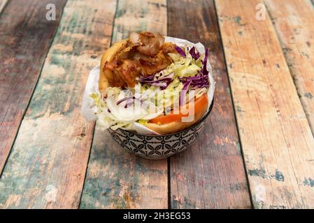 Köstliches Kebab-Sandwich mit Eisbergsalat, Rotkohl, Tomatenscheiben, weißer Zwiebel mit gehacktem gebratenem Huhn und Lamm Stockfoto