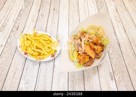 Kebab-Menü mit Hähnchen- und Lammsandwich mit Salat und Zwiebeln und Pommes frites Stockfoto