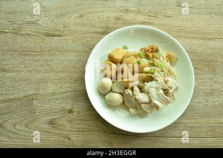 Trockene große Reisnudeln Dressing schwarzen süßen Sojabohnensauce Belag in Scheiben gekochtes Schweinefleisch und Ball auf dem Teller Stockfoto