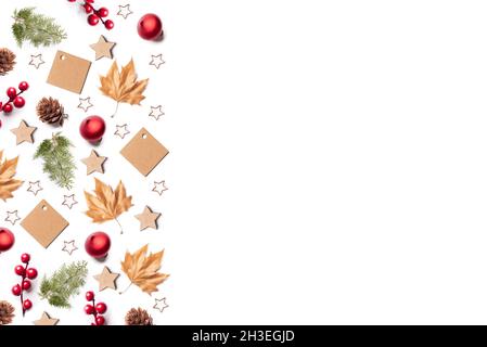 Weißer Weihnachtshintergrund oder Muster auf der linken Seite mit Tannenzapfen, Weihnachtskugeln, Sternen, Kiefernzweigen und getrockneten Blättern Stockfoto