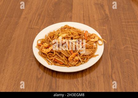 Asiatische Rezept von Nudeln mit Gemüse und Garnelen mit Sojasauce auf Holztisch anbraten Stockfoto