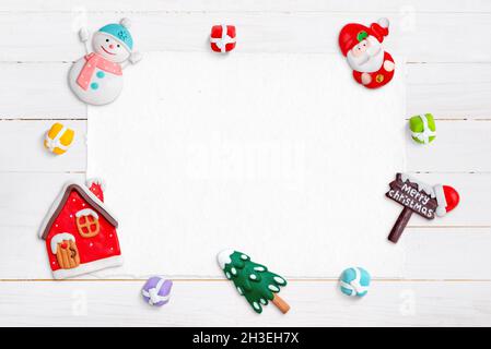 Leeres Papier oder weißer Holzschreibtisch für Grußtext, umgeben von Weihnachtsdekorationen Stockfoto
