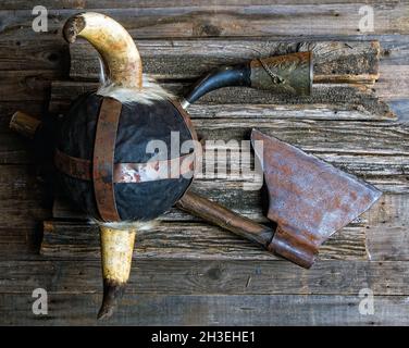 Schlacht Axt gehörnten Helm und viking Signalhorn auf rauen Holztisch Draufsicht Stockfoto