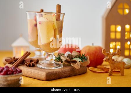 Zwei Gläser apfelweißer Glühwein auf Holzuntersetzer. Weihnachtsgetränk mit Zimt, Früchten Stockfoto
