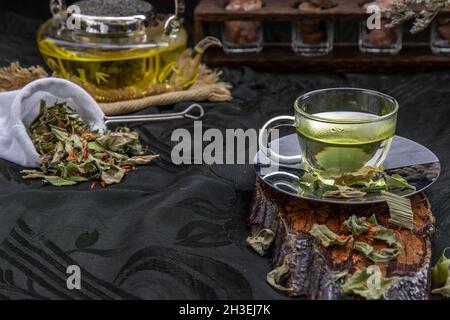 Eine Tasse Pandanblatt-Tee, indische Marschen Flabane Pflanzen Blätter mit Safflower getrocknet (Saffron-Ersatz) auf dunklem Hintergrund. Thailändische Kräuterpflanze und -Alt Stockfoto