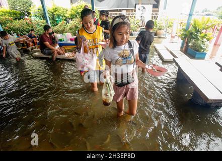 Pathum Thani, Thailand. Oktober 2021. Im Viertel Nakhon Chai Si waten die Menschen mit ihren Nudelschüsseln durch einen überfluteten Nudelladen. (Foto von Chaiwat Subprasom/SOPA Images/Sipa USA) Quelle: SIPA USA/Alamy Live News Stockfoto