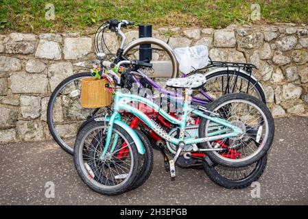 Familie von Fahrrädern. Zusammengekettete Fahrräder für Erwachsene und Kinder sind an einem Fahrradparkplatz in Southend on Sea, Essex, Großbritannien, befestigt. Der Rat hat die Post bereitgestellt Stockfoto