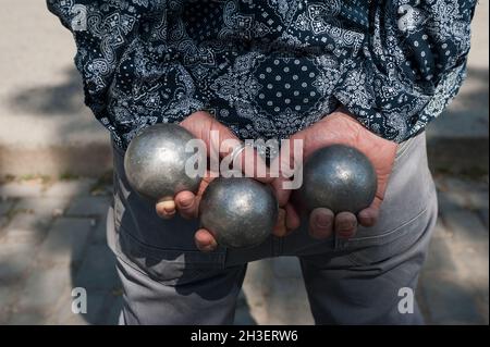 22.05.2016, Berlin, Deutschland, Europa - Nahaufnahme mit Händen eines Spielers, der Boules Petanque-Schalen im Mauerpark im Stadtteil Prenzlauer Berg hält. Stockfoto