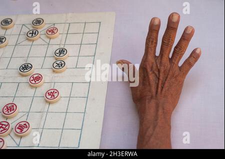 21.01.2018, Singapur, Republik Singapur, Asien - Nahaufnahme zeigt die Hand eines älteren Mannes, der in Chinatown chinesisches Schach spielt. Stockfoto