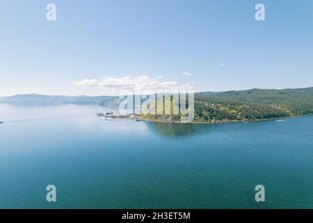 Der Baikalsee ist ein wunderschönes blaues Juwel, eingerahmt von malerischen Bergen und Wäldern. Epische filmische Luftaufnahme des Baikalsees. Luftaufnahme des blauen Sees und Stockfoto