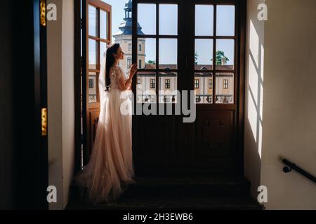 Eine elegante Braut auf dem Balkon eines alten Schlosses in der Stadt Nesvizh. Stockfoto