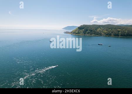 Der Baikalsee ist ein wunderschönes blaues Juwel, eingerahmt von malerischen Bergen und Wäldern. Epische filmische Luftaufnahme des Baikalsees. Luftaufnahme des blauen Sees und Stockfoto