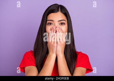 Foto von süß beeindruckt Frau gekleidet rot T-Shirt Arme schließen Nase Lippen isoliert lila Farbe Hintergrund Stockfoto