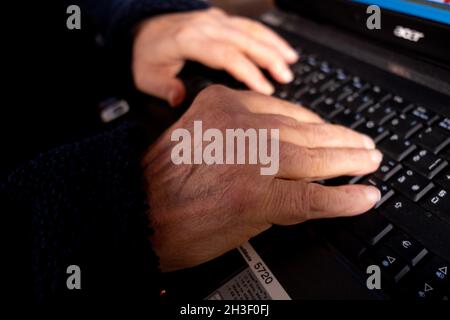 Nahaufnahme des Mannes, der die Hände am Computer hält. Venedig, Italien, 28. Oktober 2021. (MVS) Stockfoto