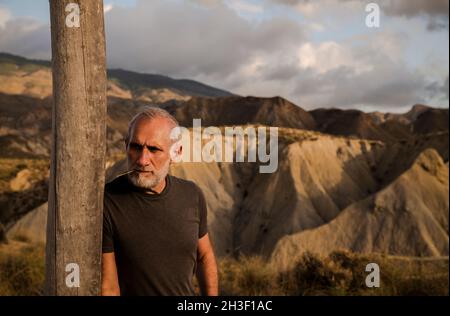 Erwachsener Mann in der Wüste Tabernas in Almeria, Spanien, gegen bewölkten Himmel Stockfoto