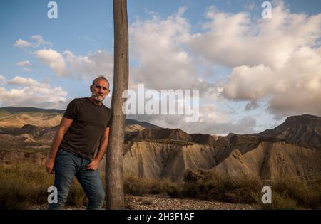 Erwachsener Mann in der Wüste Tabernas in Almeria, Spanien, gegen bewölkten Himmel Stockfoto