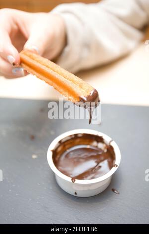 Spanische Churros mit dunkler Schokoladensauce Stockfoto