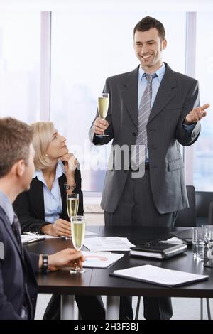 Fröhlicher Geschäftsmann, der im Büro anstockt Stockfoto
